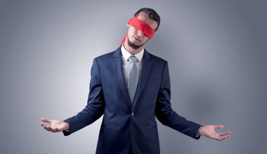 Kapalı göz işadamı bir duvarın önünde