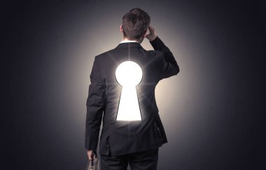 Sırtında siyah anahtar deliği ile ayakta adam