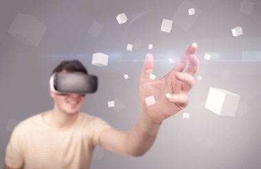 Adam sanal gerçeklik gözlüğü takıyor.