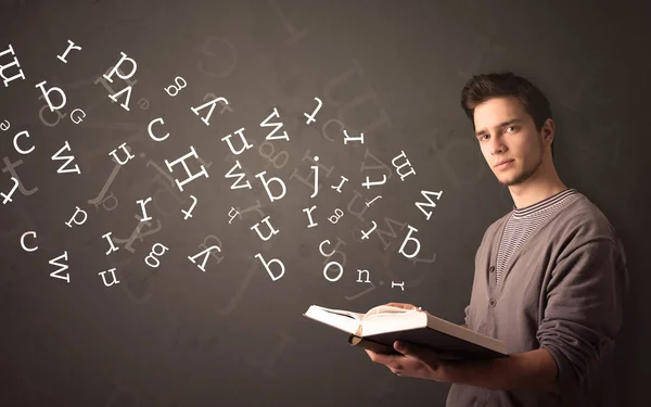 Young man holding book with letters — Stock Photo, Image