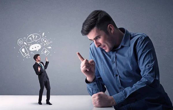 Young businessman fighting with miniature businessman — Stock Photo, Image