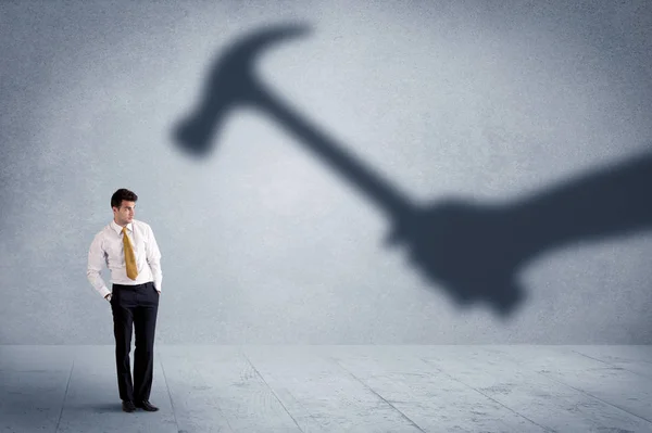 Business person afraid of a shadow hand holding hammer concept — Stock Photo, Image