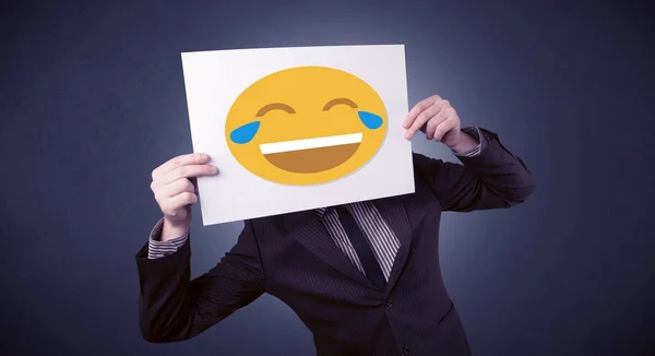 Uomo d'affari in possesso di carta con emoticon ridere — Foto Stock