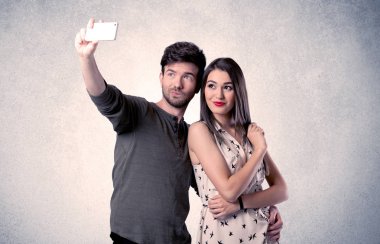 Mutlu çift temiz duvarlı selfie çekiyor.