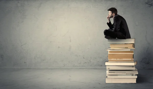 Student sitting on stack of books — Stock Photo, Image