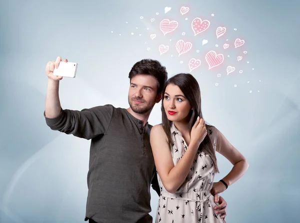 Pár zamilovaný brát selfie s červeným srdcem — Stock fotografie