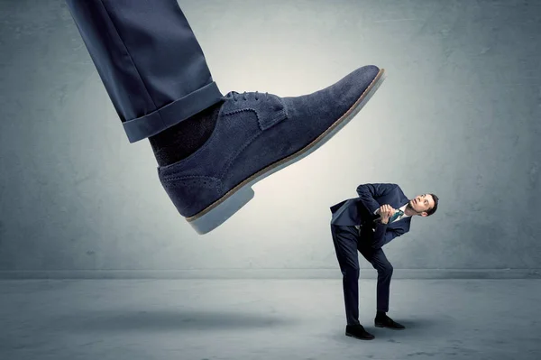 Employee getting trampled by big shoe — Stock Photo, Image