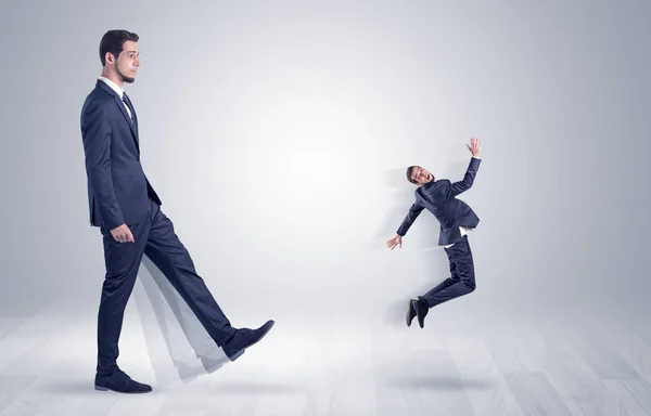 Giant businessman kicking out little businessman — Stock Photo, Image