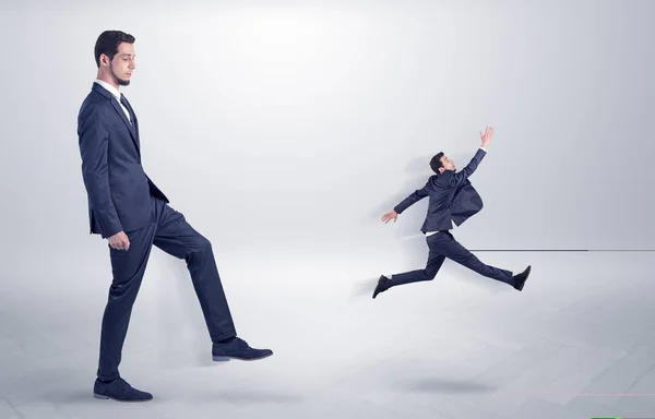 Small man fired by boss with white wallpaper — Stock Photo, Image