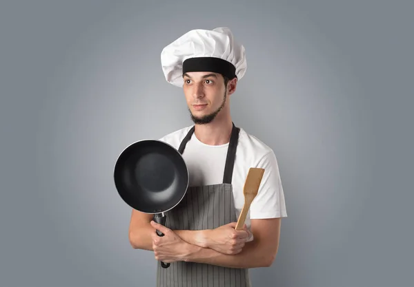 Cook with kitchen tools and empty wallpaper — Stock Photo, Image