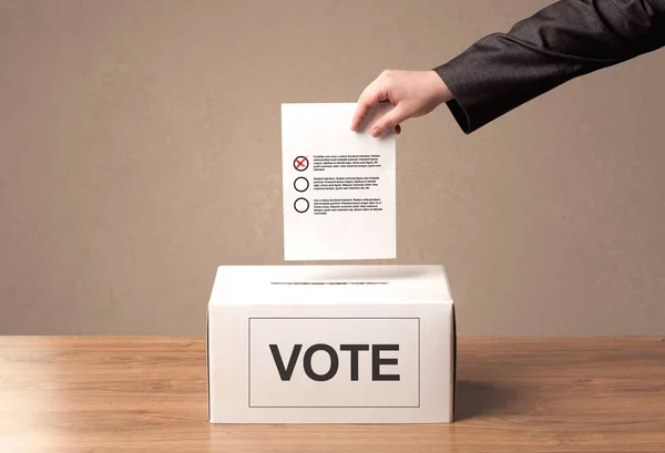 Fechar a mão masculina colocando voto em uma urna — Fotografia de Stock