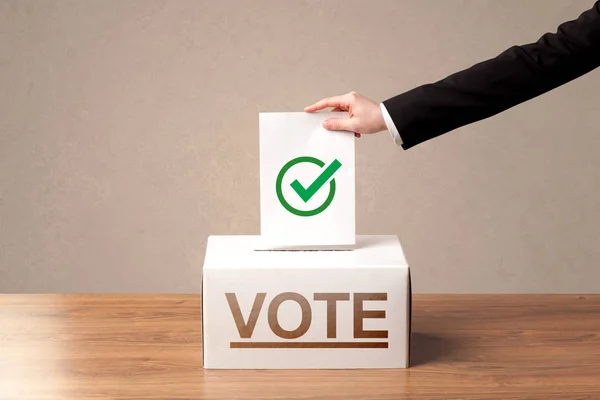 Fechar a mão masculina colocando voto em uma urna — Fotografia de Stock