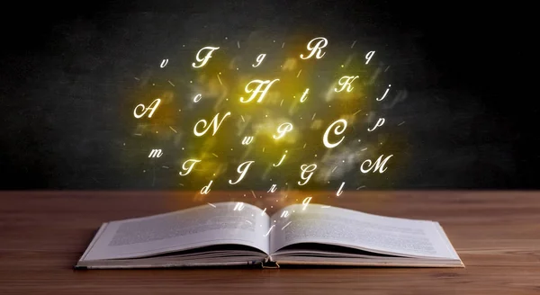 Алфавитные буквы над книгой — стоковое фото