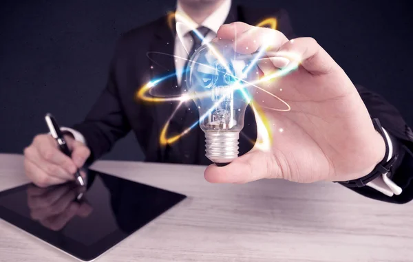 Businessman holding a colorful light bulb — Stock Photo, Image