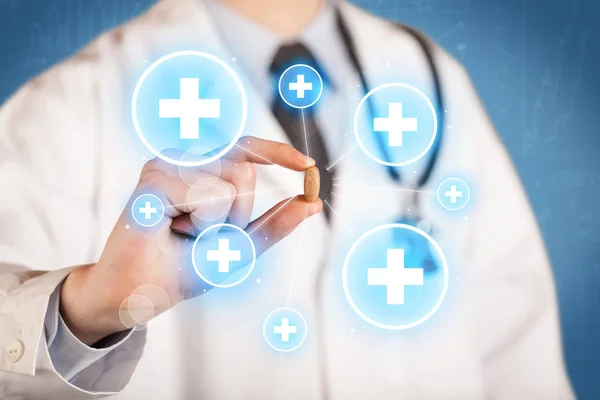 A doctor showing a pill with crosses — Stock Photo, Image