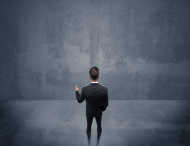 Şehir duvarının önünde duran iş adamı