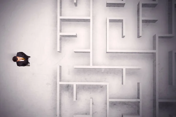Uomo d'affari confuso in piedi a un muro labirinto — Foto Stock