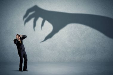 İş kişi büyük canavar pençe gölge kavramı korkuyor