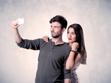 Mutlu çift temiz duvarlı selfie çekiyor.