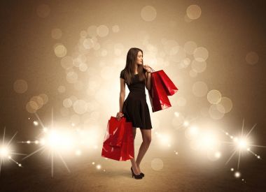 Parlak ışıklarda çantalı alışveriş yapan kadın.