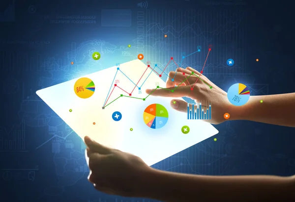 Hände berühren eine glasartige Tablette mit Diagrammen — Stockfoto