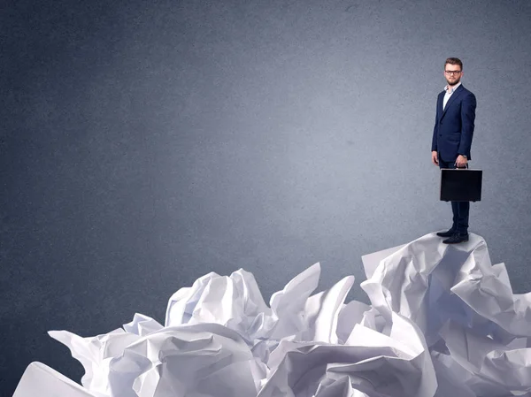 Businessman standing on crumpled paper — Stock Photo, Image