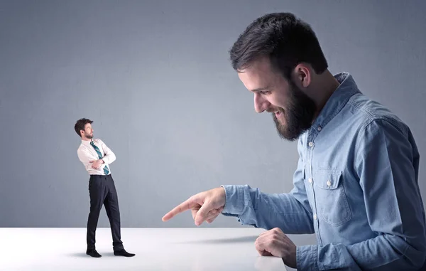 Young businessman fighting with miniature businessman — Stock Photo, Image