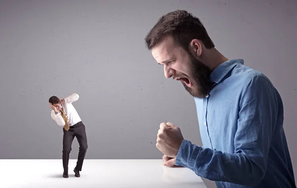 Joven hombre de negocios luchando con empresario en miniatura —  Fotos de Stock