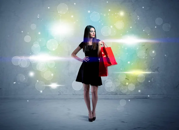 Senhora do shopping com sacos de compras e luz de brilho — Fotografia de Stock