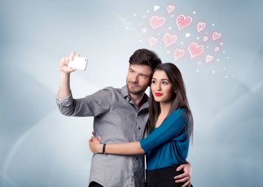 Aşık çift kırmızı kalple selfie çekiyor.