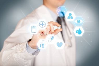 Beyazlı bir doktor elinde hap tutuyor.