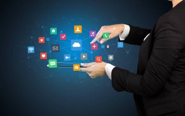 Tablet ve uygulama simgeleri yukarıda tutan el