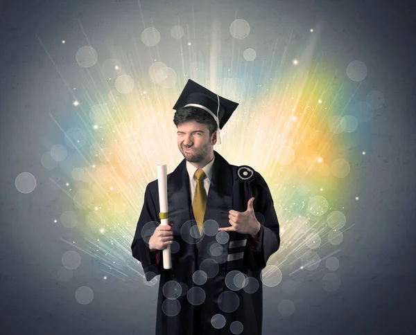 Šťastný absolvent s barevnými bokeg světla v pozadí — Stock fotografie