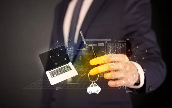 Businessman holding keys with graphs around — Stock Photo, Image