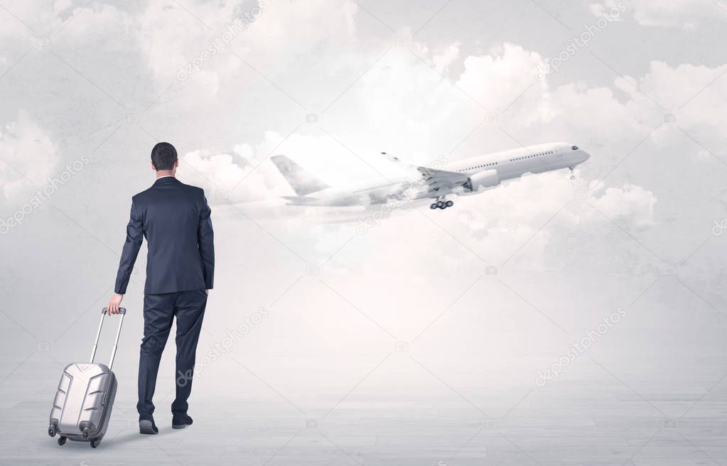 Businessman with luggage walking to airplane