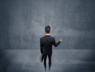 Şehir duvarının önünde duran iş adamı