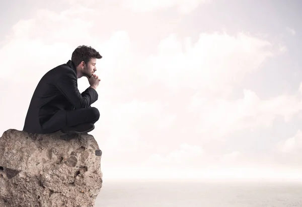 Hombre de negocios sentado en el borde de piedra — Foto de Stock