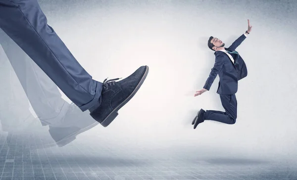 Businessman foot kicking small businessman — Stock Photo, Image