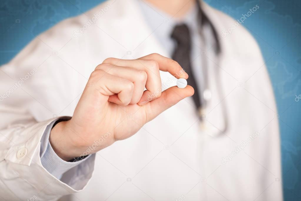 Doctor in white holding a pill