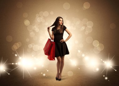 Parlak ışıklarda çantalı alışveriş yapan kadın.