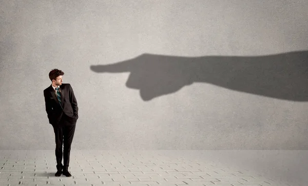 Pessoa de negócios olhando para a enorme mão sombra apontando para ele conc — Fotografia de Stock