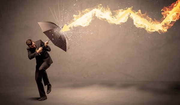 Homme d'affaires se défendant d'une flèche de feu avec un parapluie — Photo