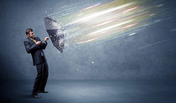 Business man defending light beams with umbrella concept — Stock Photo, Image