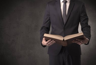 Elinde kitap tutan bir işadamı.