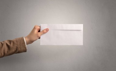 Zarf boş duvar arka plan ile tutan el