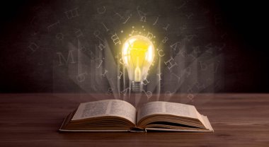 Harfler ve kitap üzerinde ampul 