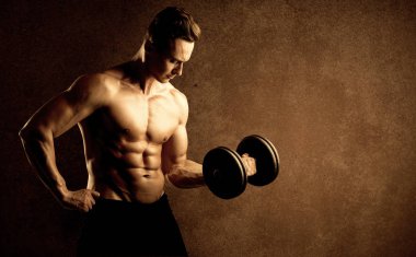 Kas formundaki vücut geliştirici sporcu ağırlık kaldırıyor 