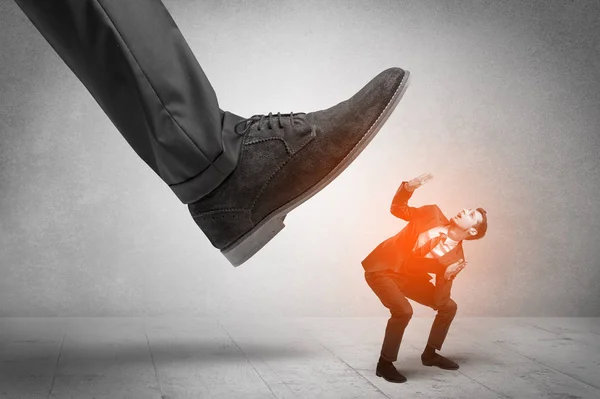 Large foot stepping down small man — Stock Photo, Image