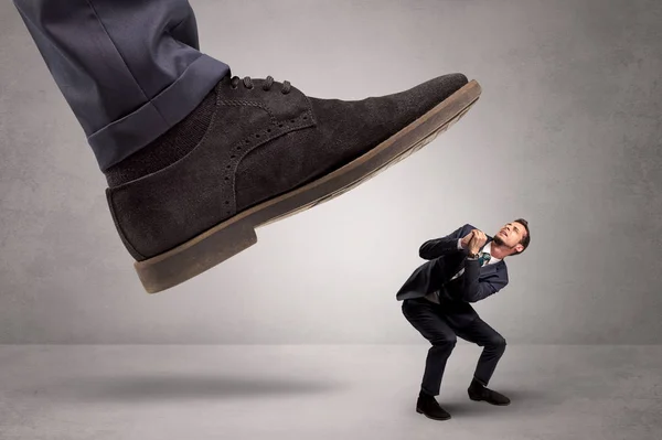 Klein mannetje met voeten getreden door de grote kracht — Stockfoto