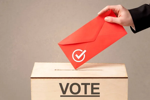 Fechar a mão masculina colocando voto em uma urna — Fotografia de Stock